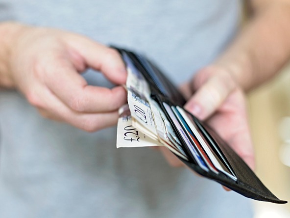 person taking bank notes out of a wallet 